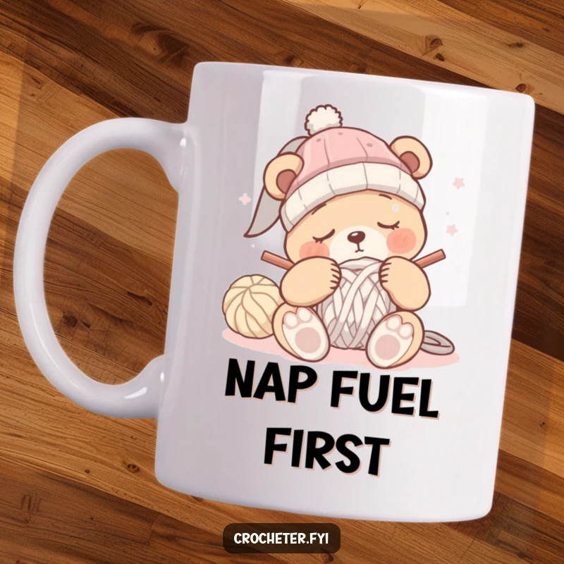 Funny sleepy bear mug showing a bear struggling to crochet a hat, eyes half-closed, clearly about to doze off.