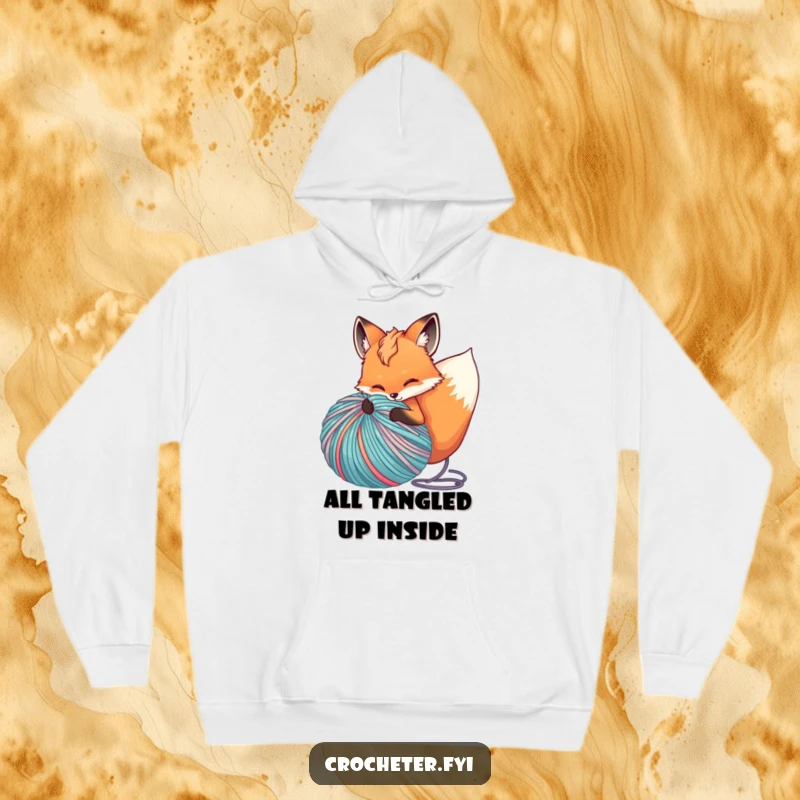 Funny hoodie depicting a joyful fox tangled in a massive, unraveling ball of vibrant yarn, perfect for cozy crafting.