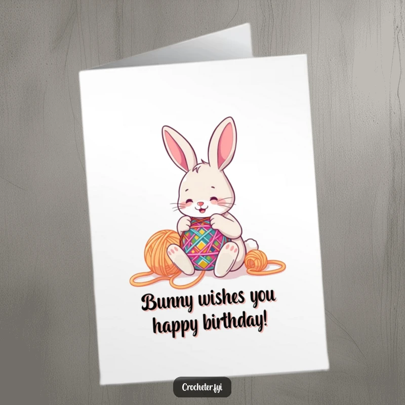 Funny Free Printable Birthday Card: A happy bunny is busy stitching a colorful pattern with big yarn. Downloadable crafting cheer.